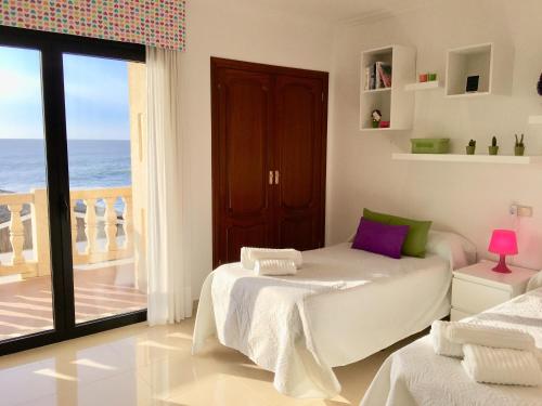 a bedroom with a bed and a balcony with the ocean at Casa Con Piscina Junto Al Mar in Oia