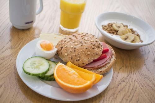 a plate of food with a sandwich and a bowl of fruit at Best Western Eurostop Orebro in Örebro