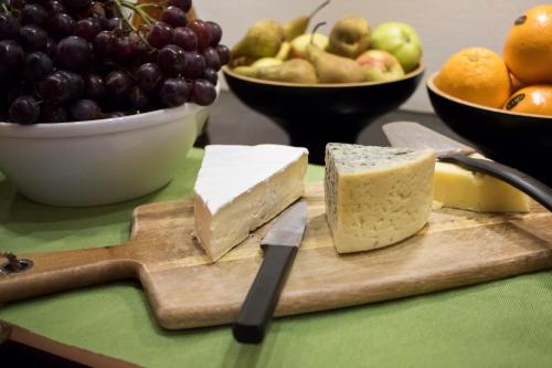 a cutting board with cheese and fruit on a table at Best Western Eurostop Orebro in Örebro