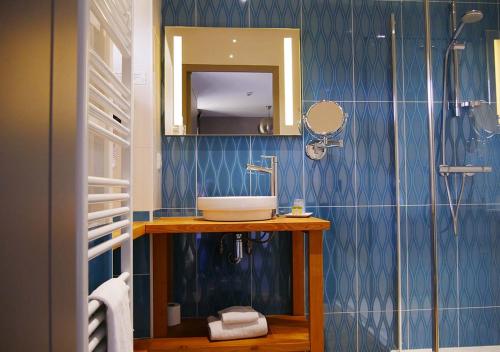 ein Bad mit einem Waschbecken und einem Spiegel in der Unterkunft Logis - Auberge de l'Abbaye in Thiron-Gardais