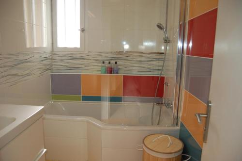 a bathroom with a tub with a rainbow shower at La Maison de Peggy in Garons