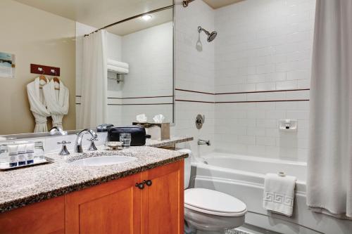 uma casa de banho com um lavatório, um WC e uma banheira em Pan Pacific Whistler Mountainside em Whistler