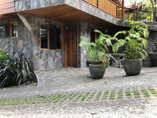 a house with two potted plants in front of it at Arco Iris Lodge in Monteverde Costa Rica