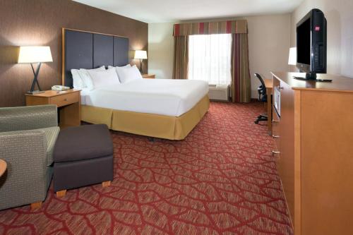 a hotel room with a bed and a television at Holiday Inn Express Grants Pass by IHG in Grants Pass