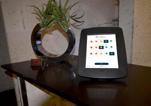 a tablet computer sitting on a table with a vase at qp Hotels Arequipa in Arequipa