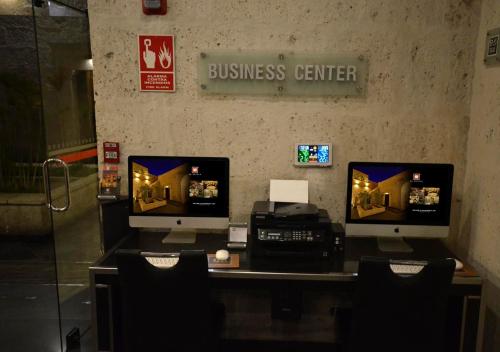 a business center with two computer monitors and a printer at qp Hotels Arequipa in Arequipa