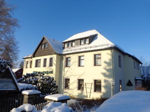 a large white house with snow on the ground at Ferienhotel Augustusburg in Augustusburg