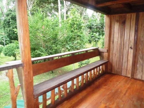a wooden porch with a bench on the outside at Hotel & Cabinas Nadine in Cahuita