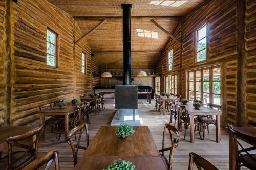 a dining room with wooden walls and tables and chairs at Pousada Tankamana in Itaipava