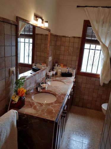 a bathroom with two sinks and a large mirror at Cortijo de la Cruz in Iznájar