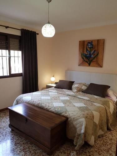 a bedroom with a large bed with a wooden table at Cortijo de la Cruz in Iznájar
