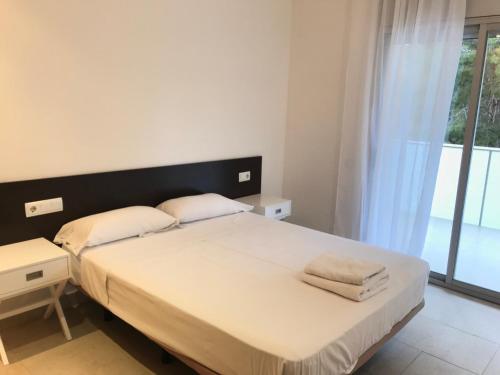 a bedroom with a bed and a large window at Saval Spa Aqquaria Family Complex in Salou