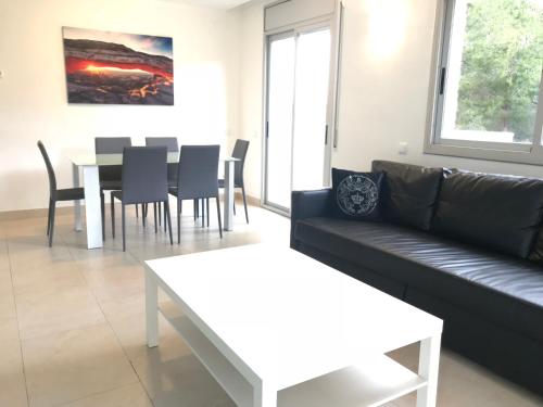 a living room with a couch and a table with chairs at Saval Spa Aqquaria Family Complex in Salou