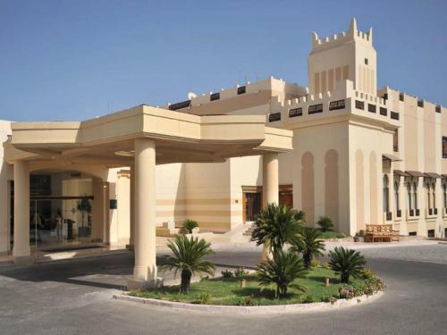 a large building with palm trees in front of it at Concorde El Salam Sharm El Sheikh Front Hotel in Sharm El Sheikh
