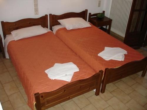 two beds with white sheets and towels on them at Elena Beach in Chania