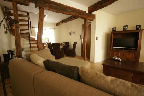 a living room with a couch and a flat screen tv at Landgasthof Em Lade in Dahlem