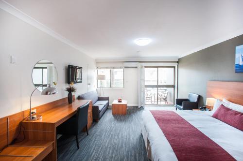 En eller flere senge i et værelse på Ramada Hotel & Suites by Wyndham Cabramatta