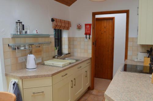 a kitchen with a sink and a counter top at Shipload Cottage in Hartland