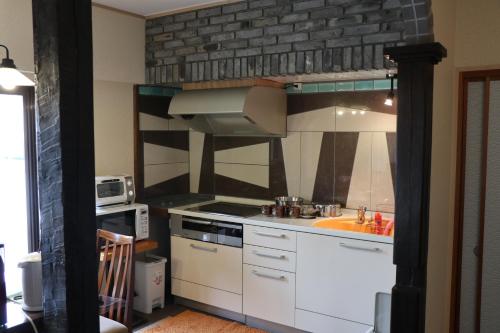 a kitchen with a sink and a stove top oven at Guest House Dohei in Kamakura