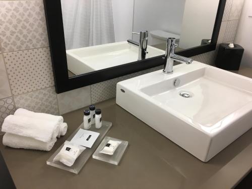 a bathroom with a white sink and a mirror at Country Inn & Suites by Radisson Ocean City in Ocean City