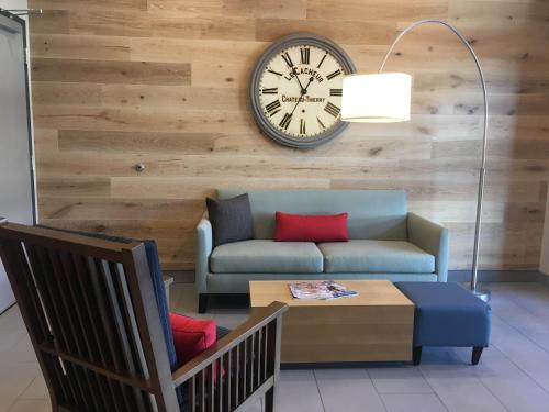 a living room with a couch and a clock on a wall at Country Inn & Suites by Radisson Ocean City in Ocean City