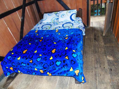 a bed with a blue blanket with butterflies on it at Posada Fin del Mundo in Mocoa