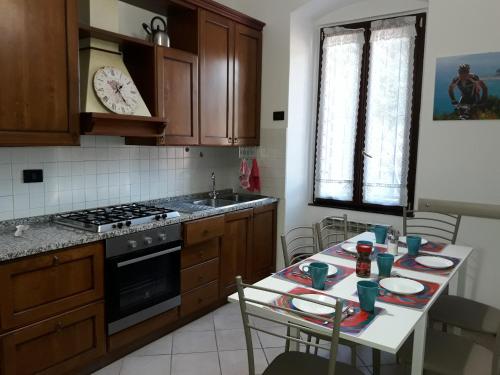 kuchnia ze stołem, krzesłami i kuchenką w obiekcie Finalborgo Location w mieście Finale Ligure