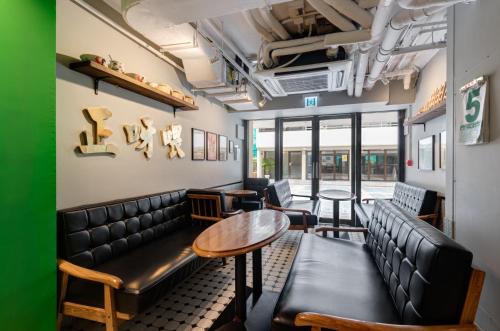 a room with a couch and a table and chairs at YHA Mei Ho House Youth Hostel in Hong Kong