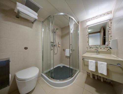 a bathroom with a shower and a toilet and a sink at YHA Mei Ho House Youth Hostel in Hong Kong