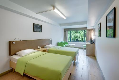 香港にあるYHA メイ ホー ハウス ユース ホステルのベッド2台とテーブルがあるホテルの部屋