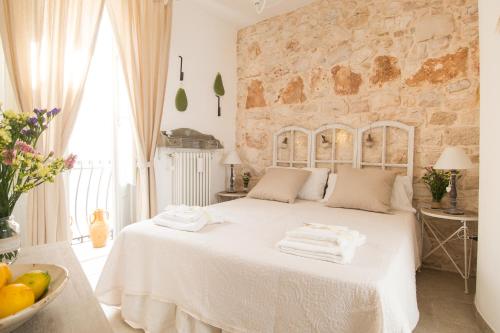 Un dormitorio con una cama blanca con toallas. en Manidibianco Apulian Relaxing Stay, en Turi