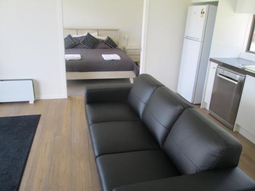 ein Wohnzimmer mit einem Sofa und einem Bett in der Unterkunft Just Red Wines Cabins in Ballandean