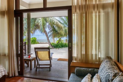 a living room with a sliding glass door leading to a patio at Fleur de Sel in Mahe