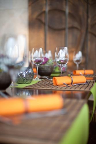 a table with wine glasses and vegetables on it at Mala Garden Design Hotel in Siófok