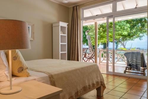 a bedroom with a bed and a sliding glass door at Fleur de Sel in Mahe