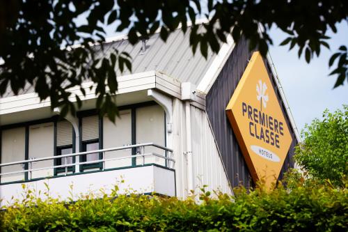 a building with a yellow sign in front of it at Premiere Classe Lyon Ouest - Tassin in Tassin-la-Demi-Lune