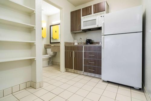 a kitchen with a white refrigerator and cabinets at Studio 6-Plano, TX - Dallas - Plano Medical Center in Plano