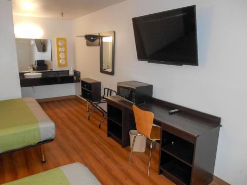 a room with a desk with a television and a bed at Motel 6-Abilene, TX in Abilene