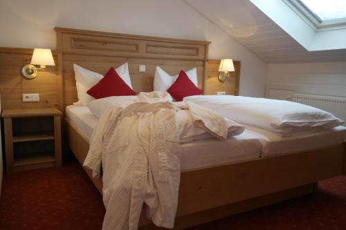a bedroom with a large bed with red and white pillows at Landhotel Windlicht in Krombach