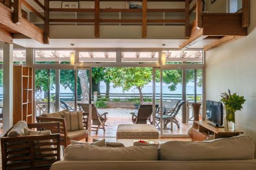 an open living room with a couch and a television at Fleur de Sel in Mahe