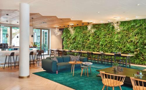 - un salon dans un restaurant avec un canapé et des tables dans l'établissement Hyatt Regency Amsterdam, à Amsterdam