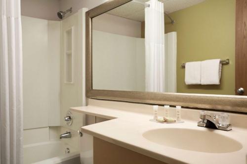 a bathroom with a sink and a mirror at Super 8 by Wyndham Westminster Denver North in Westminster