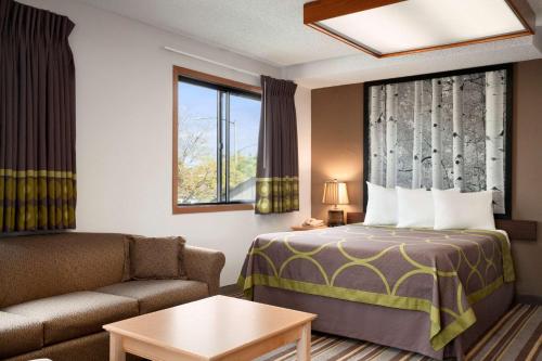a hotel room with a bed and a couch at Super 8 by Wyndham Westminster Denver North in Westminster