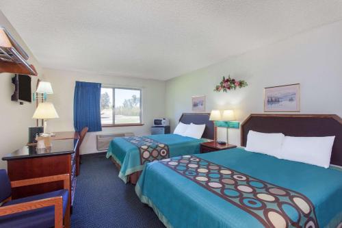 a hotel room with two beds and a desk at Super 8 by Wyndham Selma/Fresno Area in Selma