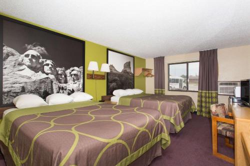 um quarto de hotel com duas camas e uma televisão em Super 8 by Wyndham Chadron NE em Chadron
