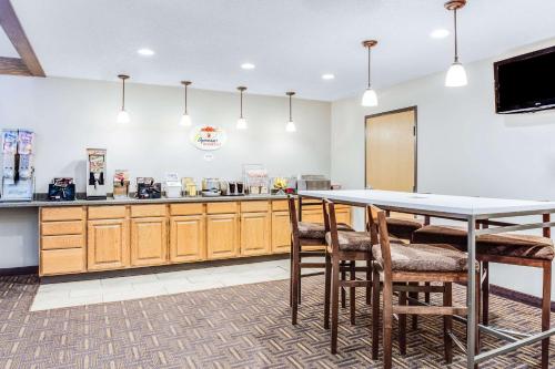 a large kitchen with a table and some chairs at Super 8 by Wyndham Green Bay Near Stadium in Green Bay