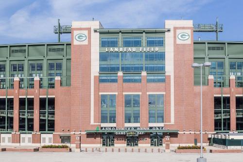 a large brick building with a sign on it at Super 8 by Wyndham Green Bay Near Stadium in Green Bay
