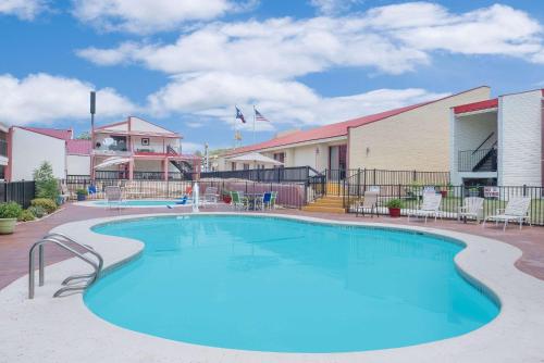 a large swimming pool in front of a building at Super 8 by Wyndham Kerrville TX in Kerrville
