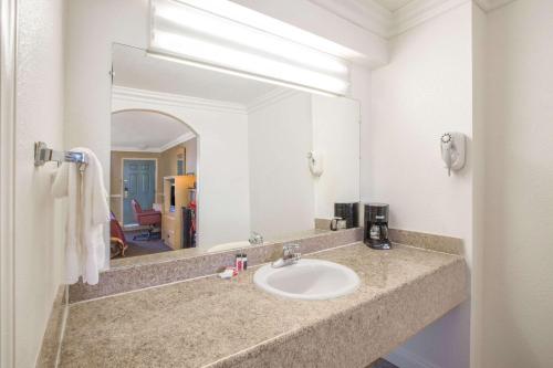 Super 8 by Wyndham Hayward Downtown في كاسترو فالي: حمام مع حوض ومرآة