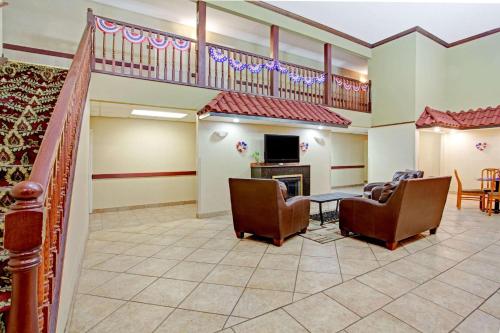 a lobby with chairs and a table and a television at Super 8 by Wyndham Forrest City AR in Forrest City